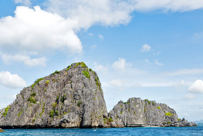 Rock formations by sea against sky
