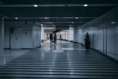 Rear view full length of people walking in corridor