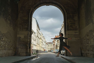 Road amidst buildings in city against sky