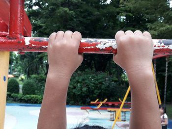 Close-up of hands holding girl playing outdoors