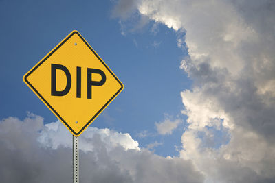 Low angle view of road sign against cloudy sky