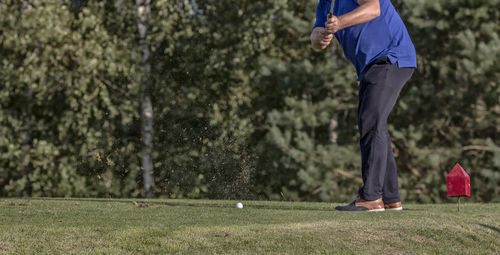 Low section of man playing golf