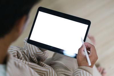 Midsection of woman using digital tablet