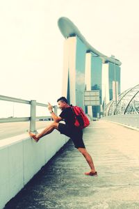 Full length of young man against built structure against clear sky