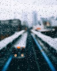 Cars on road seen through wet window