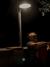 Man looking at illuminated lamp