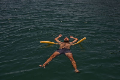 Shirtless man swimming in sea