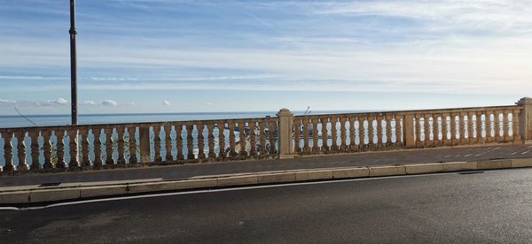 Bridge over road by sea against sky