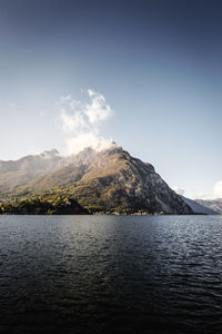 Scenic view of lake by mountains against sky