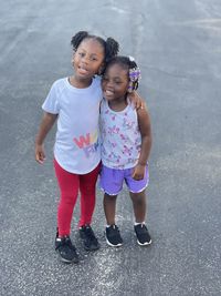 Portrait of siblings standing on road