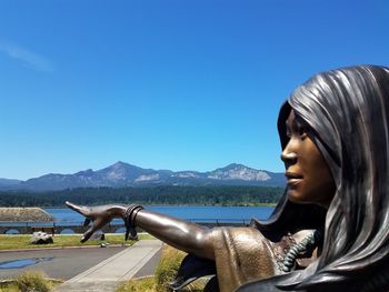 Close-up of woman against clear blue sky