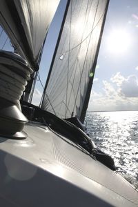 Close-up of sailboat sailing on sea against sky