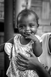 Portrait of cute baby held by mother at home