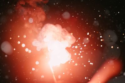 Close-up of wet glass against illuminated star field