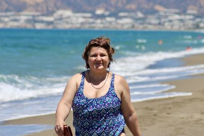 Portrait of smiling curvy woman on beach