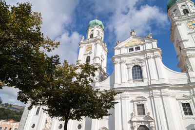 The front of st. stephen's cathedral in passau, bavaria, germany in autumn with multicolored tree 