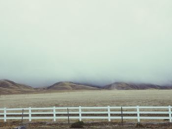 Fence on landscape against sky