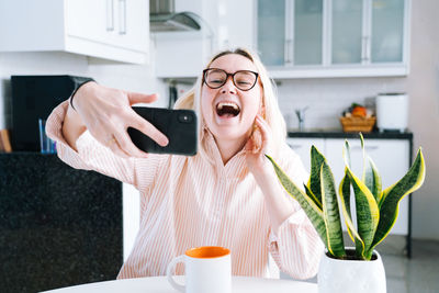 Laughing woman talking on video call at home