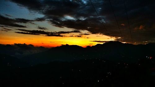 Scenic view of silhouette mountains against sky at sunset