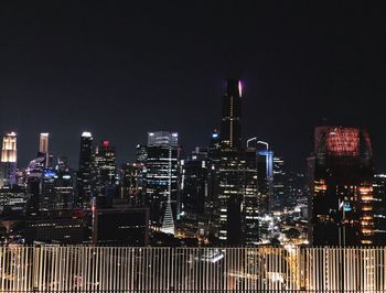 Illuminated cityscape against sky at night