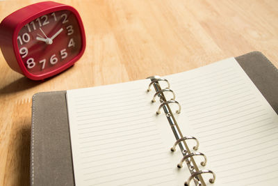 Close-up of clock and open book on table