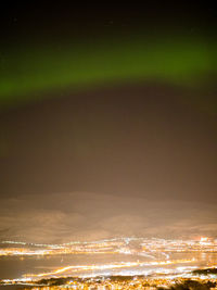 Aerial view of illuminated city against sky at night