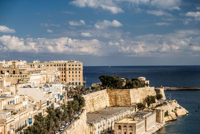 High angle view of buildings by sea against sky