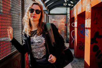 Portrait of young woman wearing sunglasses standing in city