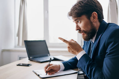 Businessman talking while pointing at office