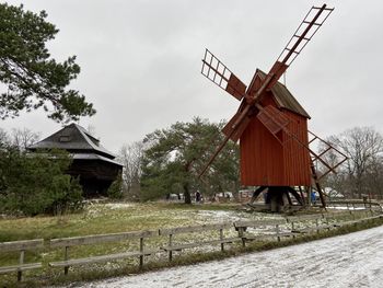 Traditional windmill on field against sky