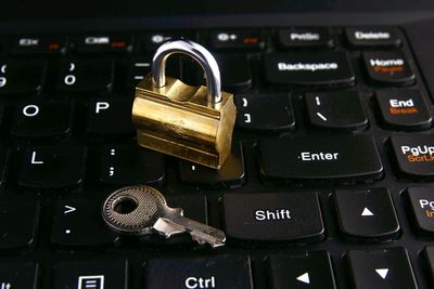 Close-up padlock and key on of computer keyboard
