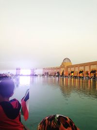 People at commercial dock against clear sky