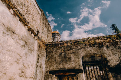 Low angle view of old building against cloudy sky