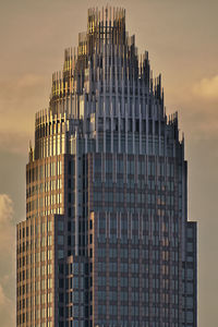 Low angle view of skyscrapers against sky at sunset