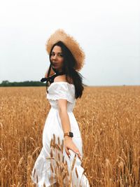 Full length of smiling young woman standing on field