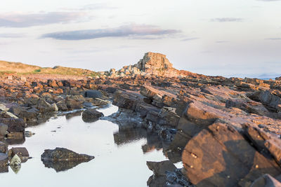 Rock formation in sea against sky