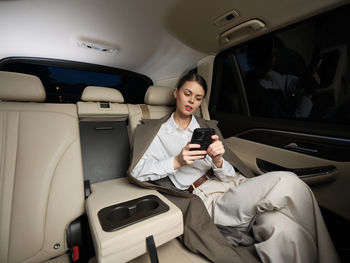 Portrait of young woman sitting in car