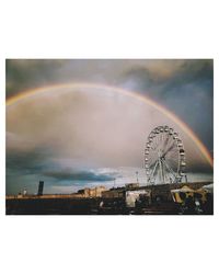Ferris wheel against rainbow in sky