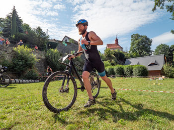 Full length of man riding bicycle on plants