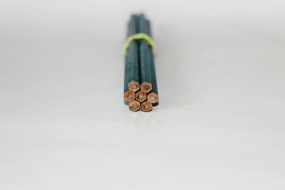Close-up of colored pencils on table against white background