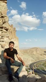 Portrait of young man sitting on rock