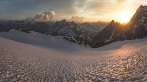 Scenic view of snowcapped mountains against sky during sunset