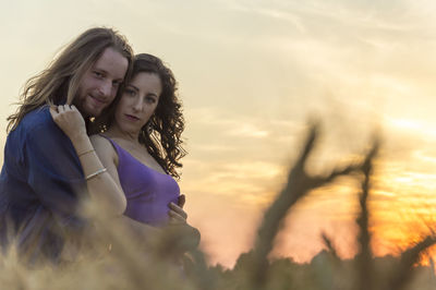 Portrait of happy woman against sky during sunset