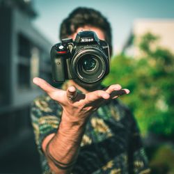 Man levitating camera while standing outdoors