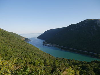 Scenic view of sea and mountains against clear sky