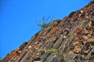 Low angle view of mountain against clear blue sky