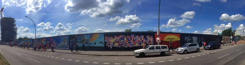 Cars on road against cloudy sky