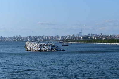 Scenic view of sea by buildings against sky