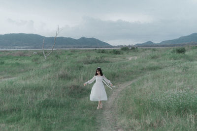 Rear view of woman standing on field