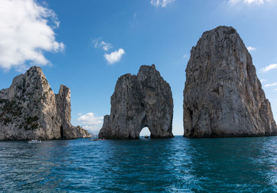 Rock formation in sea against sky